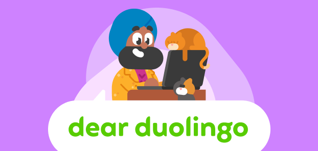 Illustration of Dear Duolingo logo with Vikram sitting at a computer in a sparkly gold jacket. Two cats are hovering nearby.