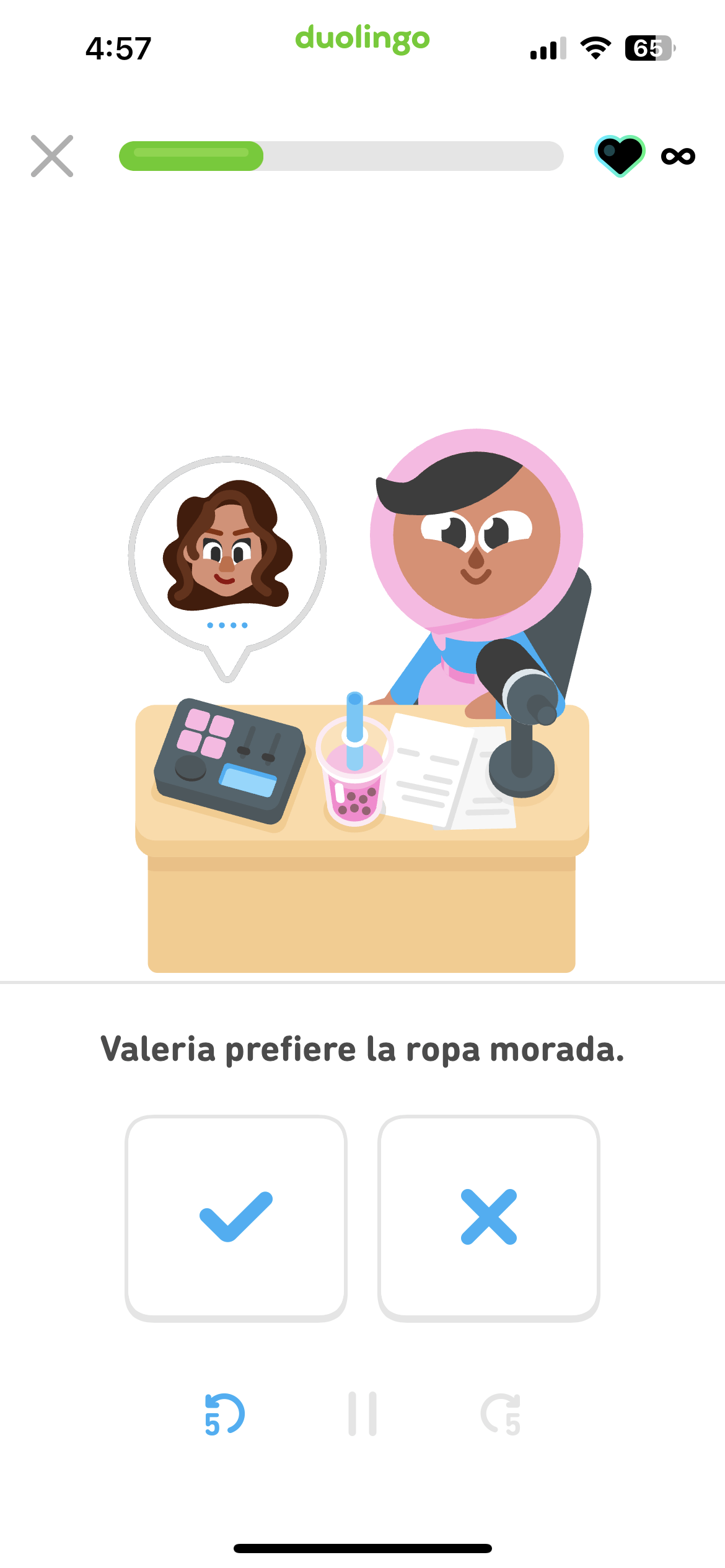 Screenshot of an illustration of Zari sitting at her DuoRadio desk in front of a microphone. The instructions include a Spanish sentence and two large buttons: a check mark and an 'X.'