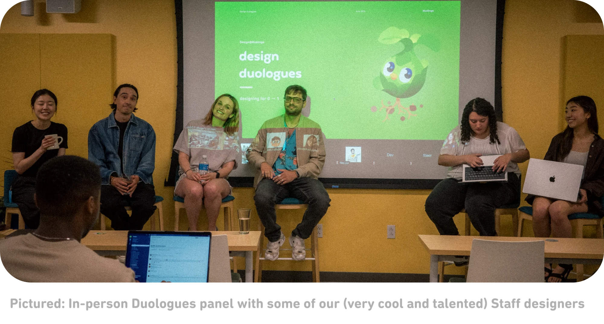 A panel of 6 people sitting in front of a screen that says "Design Duologues" with a picture of Duo's face sprouting out of a plant root.