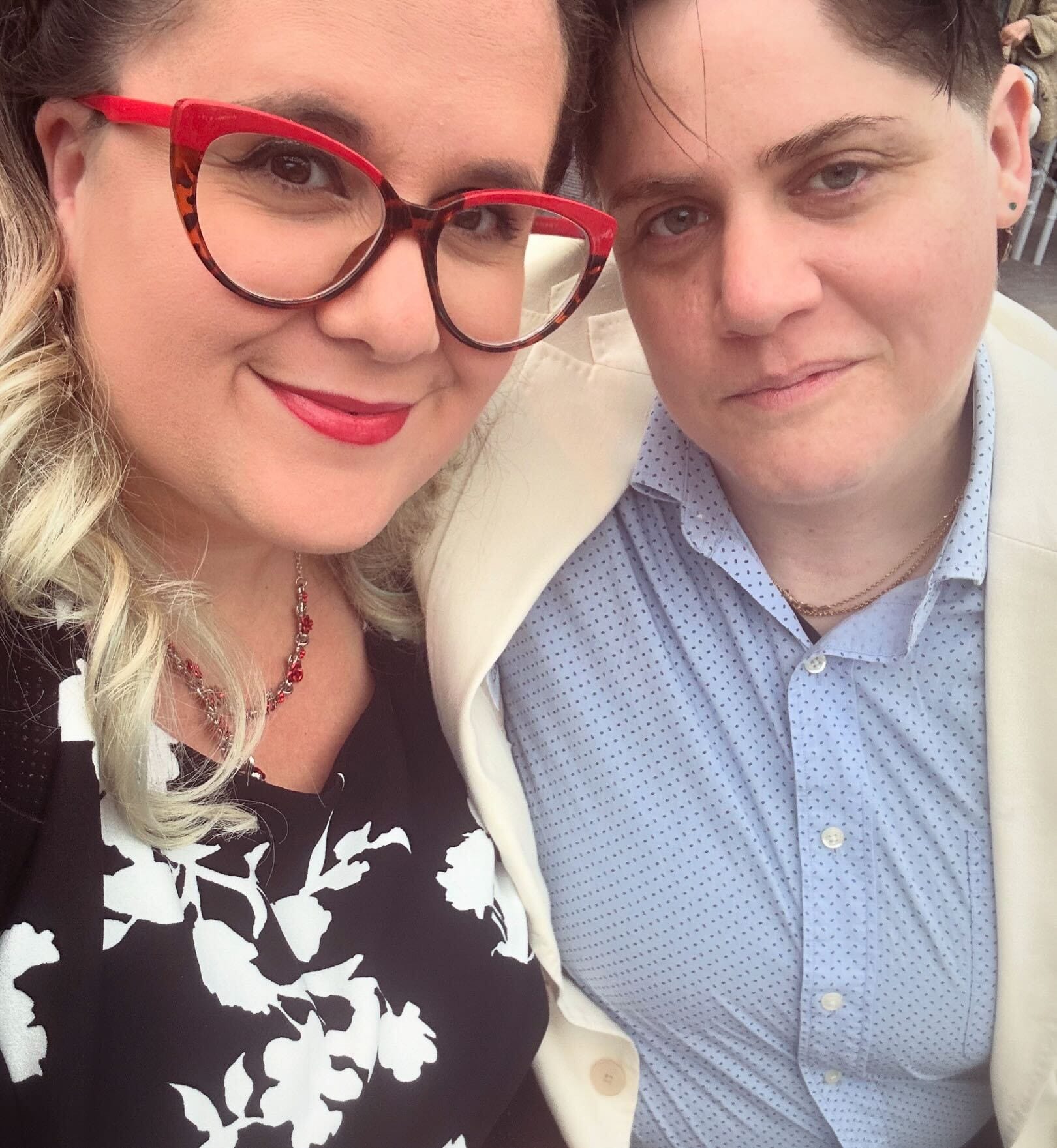 Photo de Cara debout à côté de sa partenaire, enlacées côte à côte