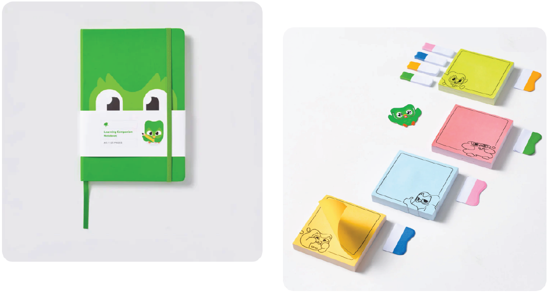 On the left, a green notebook featuring Duo the owl’s face, wrapped with a white band labeled "Learning Companion Notebook, A5 / 120 Pages." On the right, colorful sticky notes and tabs with illustrations on a white background. The notes are yellow, green, pink, and blue, each with a playful doodle of the Duolingo owl.