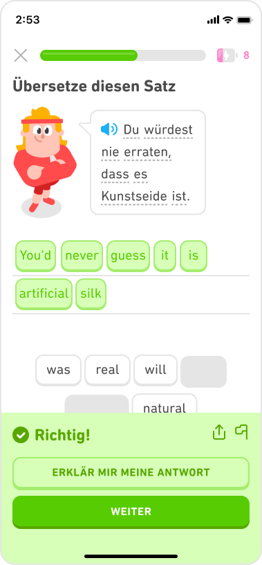 Screenshot einer Englischübung mit dem deutschen Satz „Du würdest nie erraten, dass es Kunstseide ist.“, korrekt übersetzt als „You’d never guess it is artificial silk“. Darunter befindet sich ein grünes Pop-up mit der Meldung „Richtig!“ und ein Button mit der Aufschrift „Erklär mir meine Antwort“.
