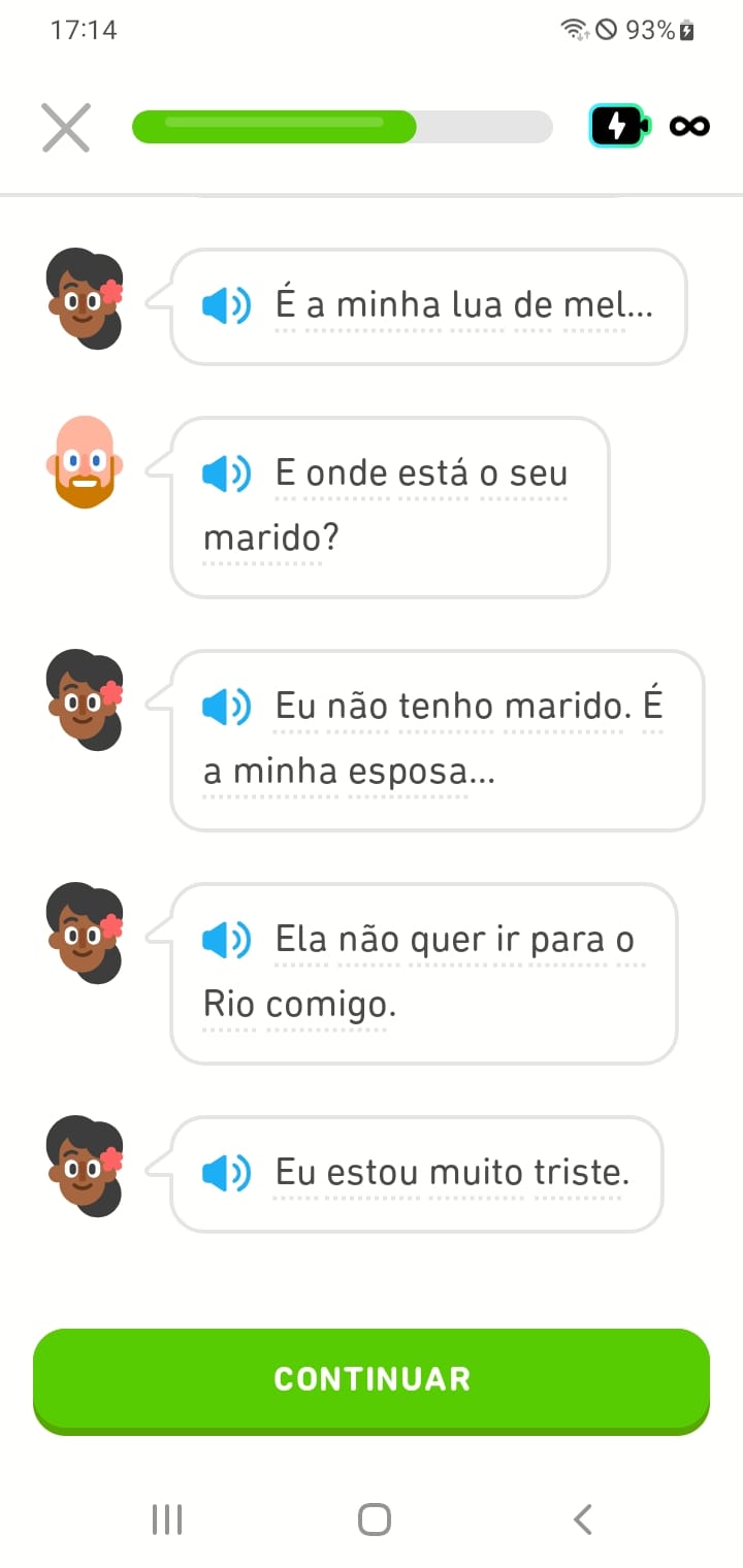 Captura de tela de um diálogo em uma História do Duolingo do curso de português entre um taxista e uma mulher que acabou de entrar no táxi. A mulher diz: “É a minha lua de mel…” O taxista pergunta: “E onde está o seu marido?” A mulher responde: “Eu não tenho marido. É a minha esposa… Ela não quer ir para o Rio comigo. Eu estou muito triste.”