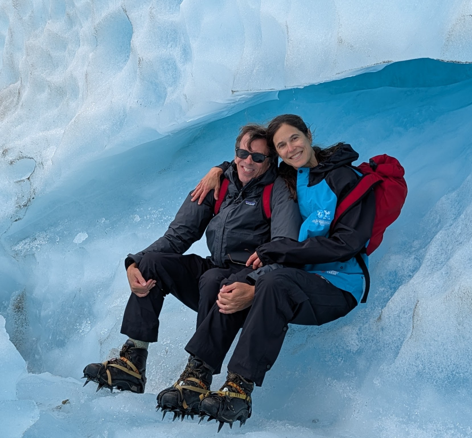 Natalie and her husband sitting in the ice on Fox Glacier in crampons.